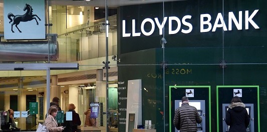 FILE PHOTO: Customers use ATMs at a branch of Lloyds Bank in London